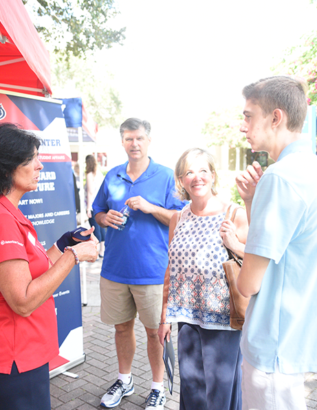 Student speaking with FAU employee at an event