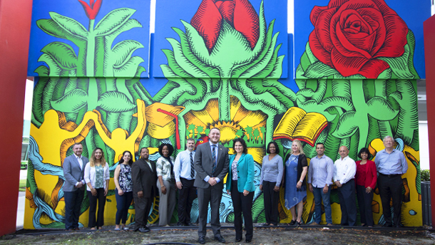 Photo of faculty and staff in front of mural