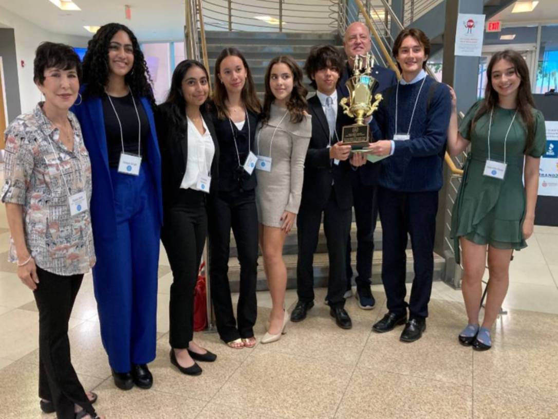 students pose with trophy