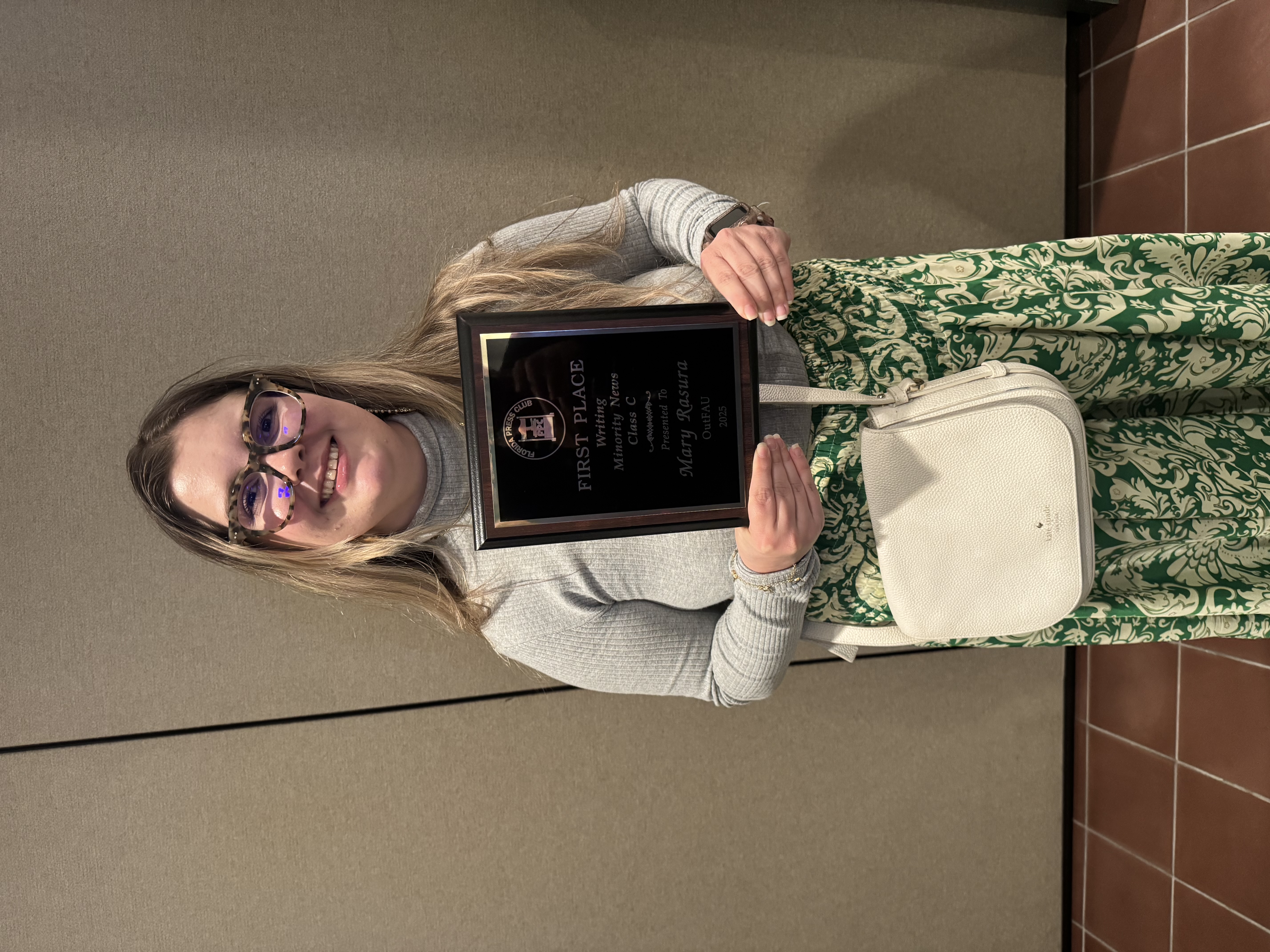 Gradute Student Mary Rasura holding plaque.