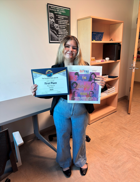 Graduate Student Mary Rasura holding First Place Sunshine State Award