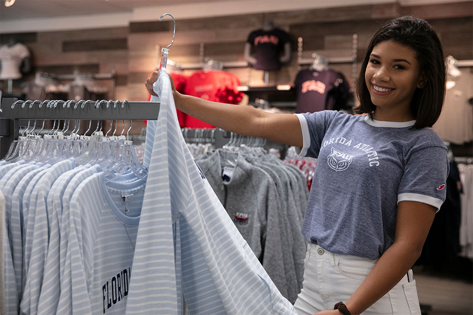 Student smiling with FAU merchandise