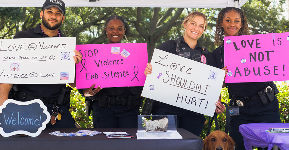 Group smiling for a photo holding up signs 