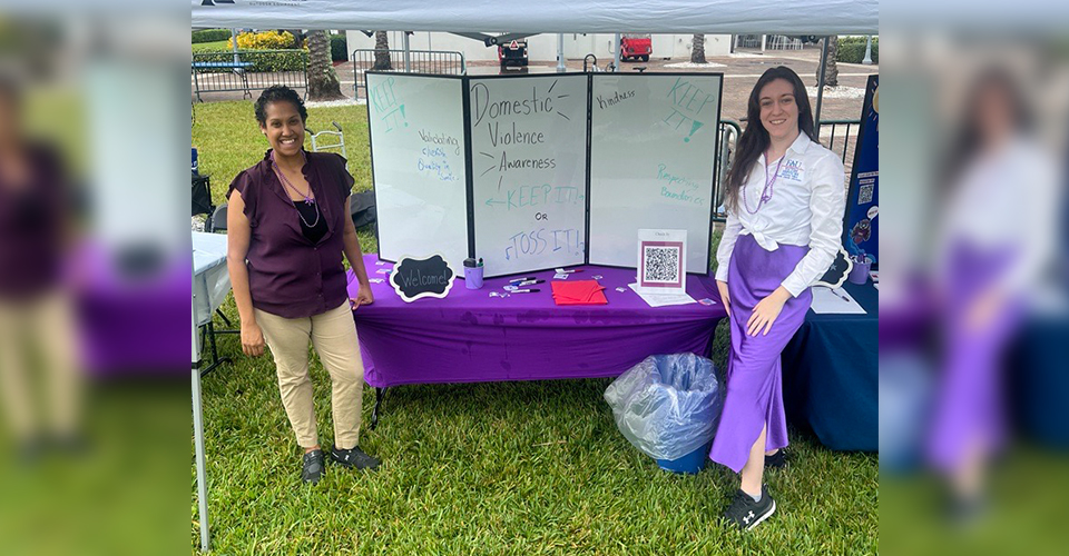 two woment smiling at sign in talble 