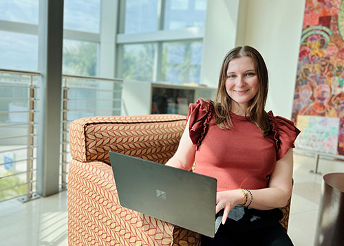 A professionally-dressed blonde woman on laptop