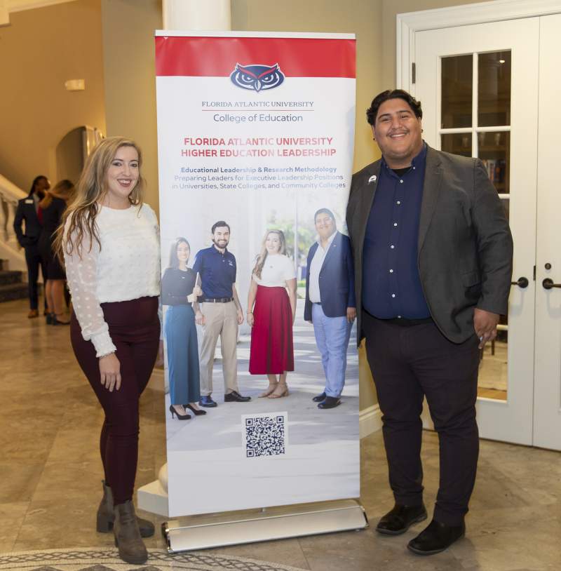 Floyd Scholars near a poster.