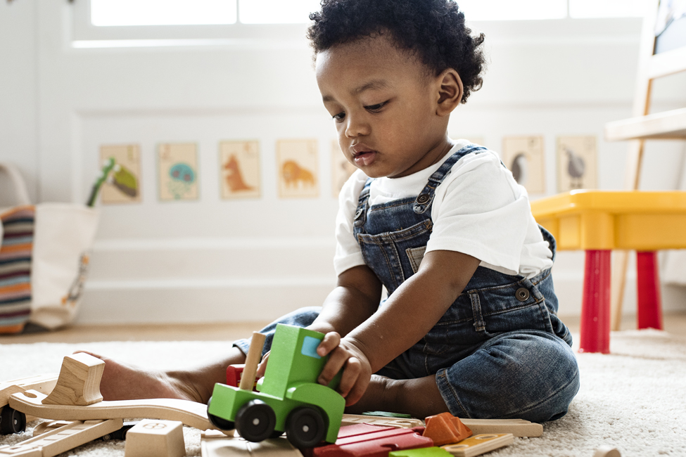 child with autism playing with wooden car