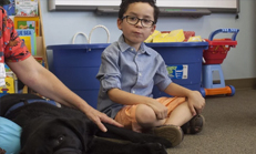 kid with autism sits beside a therapy dog