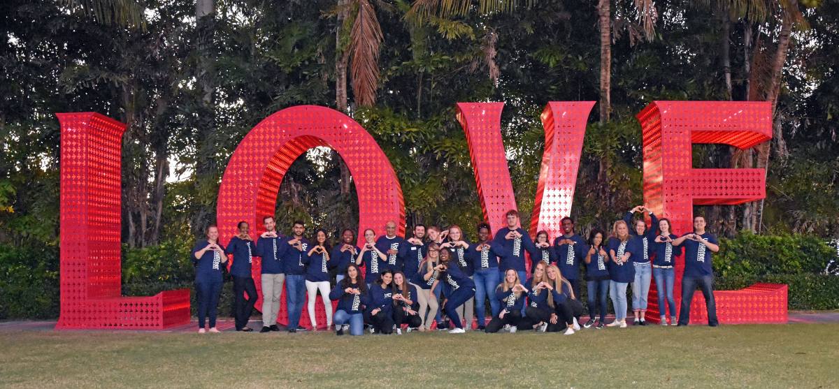 Students posing near a large statute with the letters LOVE