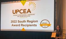 Ashley Brannan, OAE Coordinator, holds the award plaque at the UPCEA conference