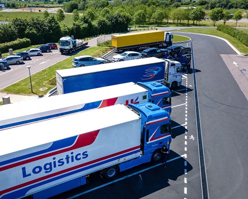 Coordination of Connected and Automated Trucks for Platooning Considering Turning Along an Arterial Corridor 