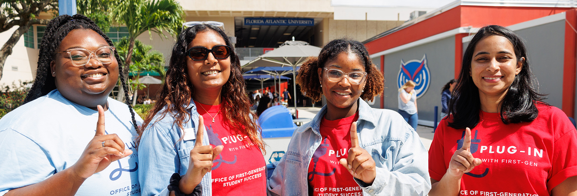 Four smiling individuals students on the Florida Atlantic Breezeway