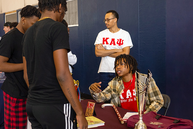 An FS life member at a recruitment table talking to another student