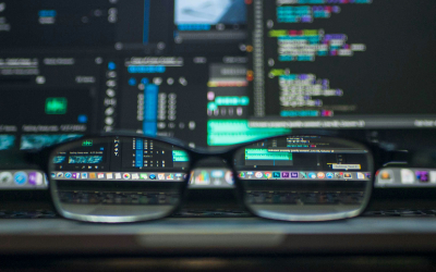 pair of glasses sitting on desk with blurry computer screen in background. Image courtesy kevin-ku unsplash 