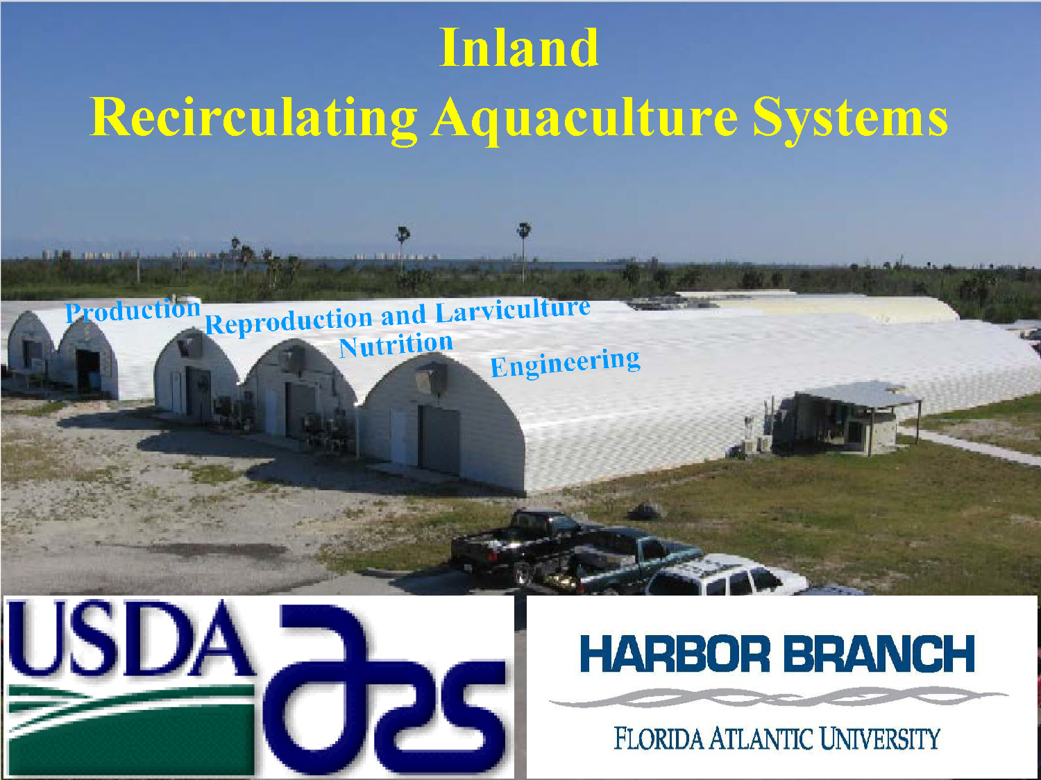 Exterior view of USDA and Harbor Branch FAU inland aquaculture research facility featuring five large white Quonset-style buildings. 