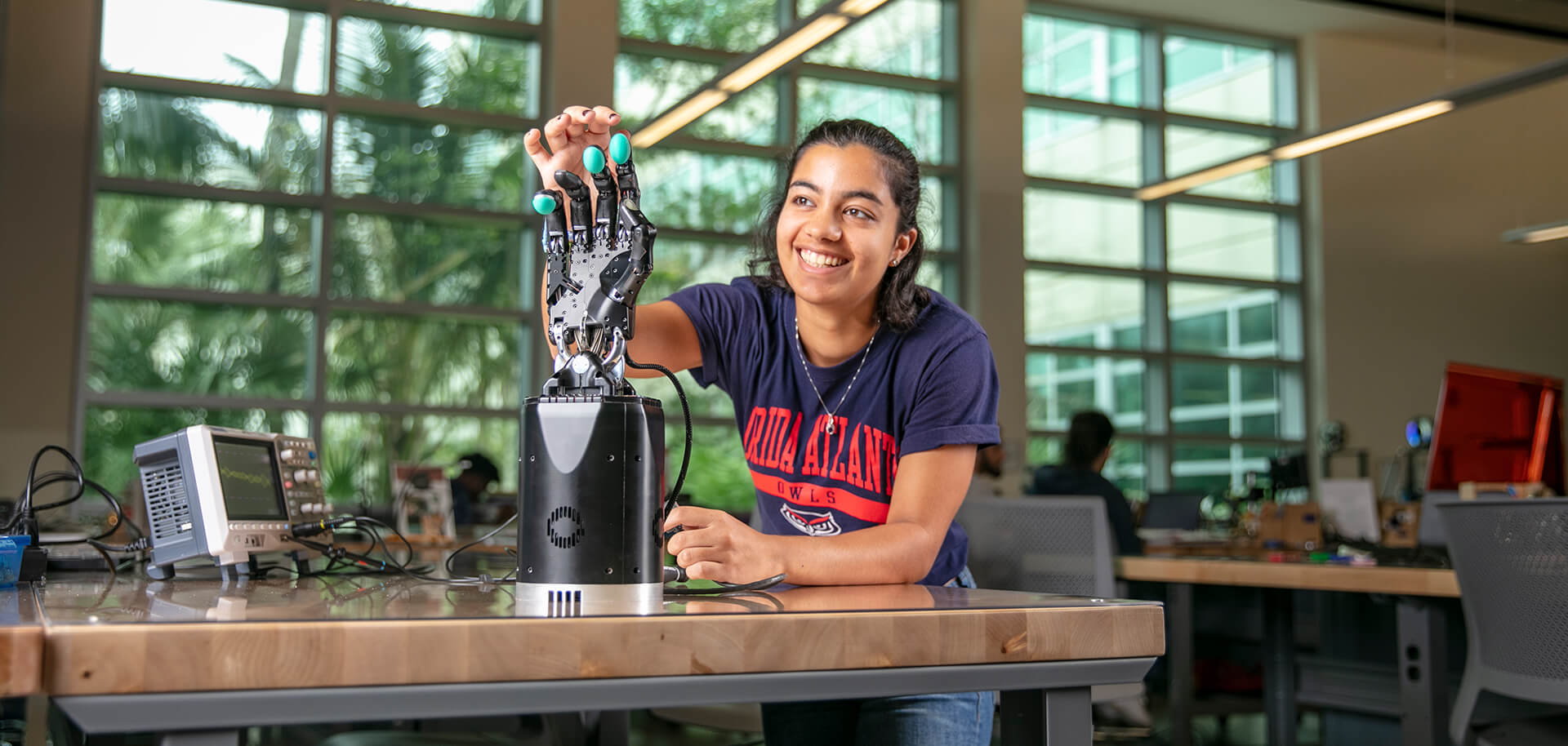 Forge Your Path - Engineering Student working on a robotic hand in a lab