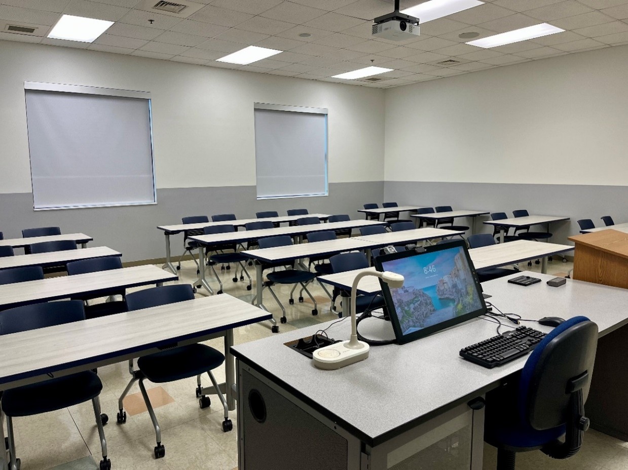 front view of classroom with tables and 32 chairs and two windows