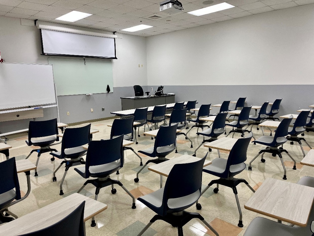 back view of classroom with 36 flip-top desk-chair combos and two windows