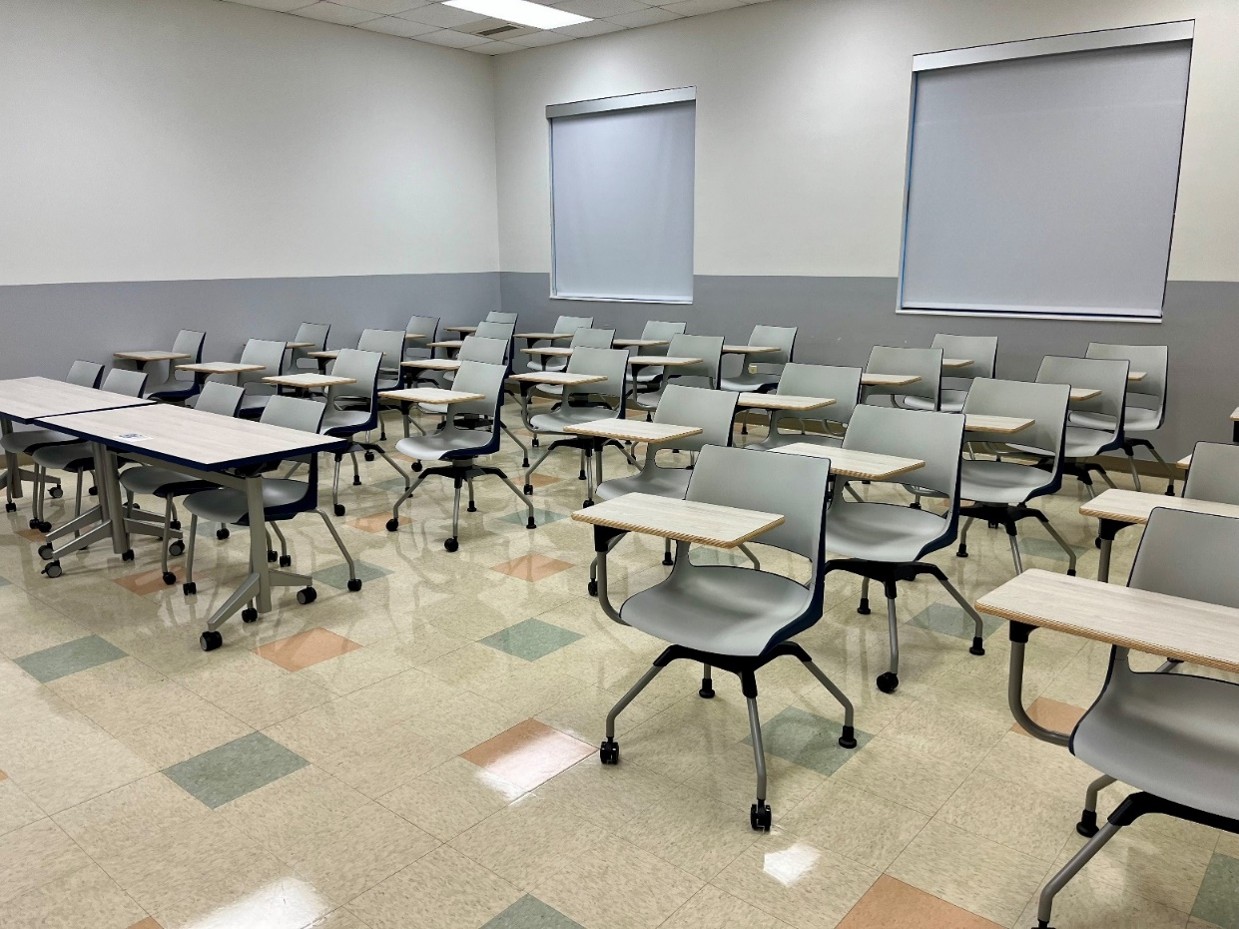 front view of classroom with 36 flip-top desk-chair combos and whiteboard