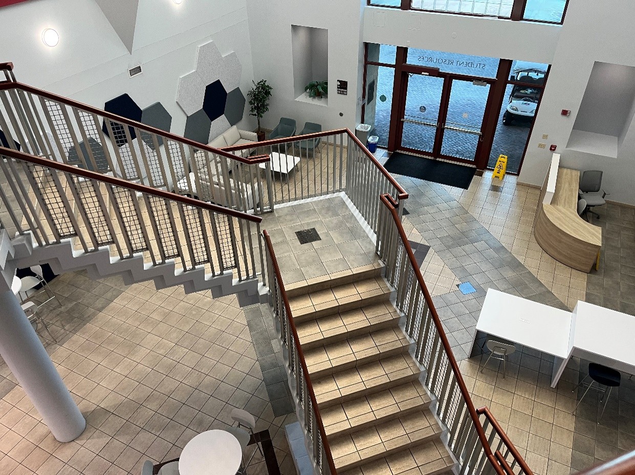view looking down open stairs with large window and doors
