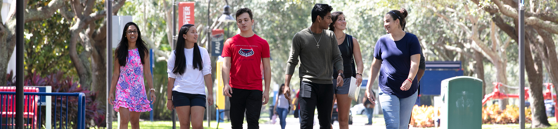 Students walking across the Jupiter campus under trees