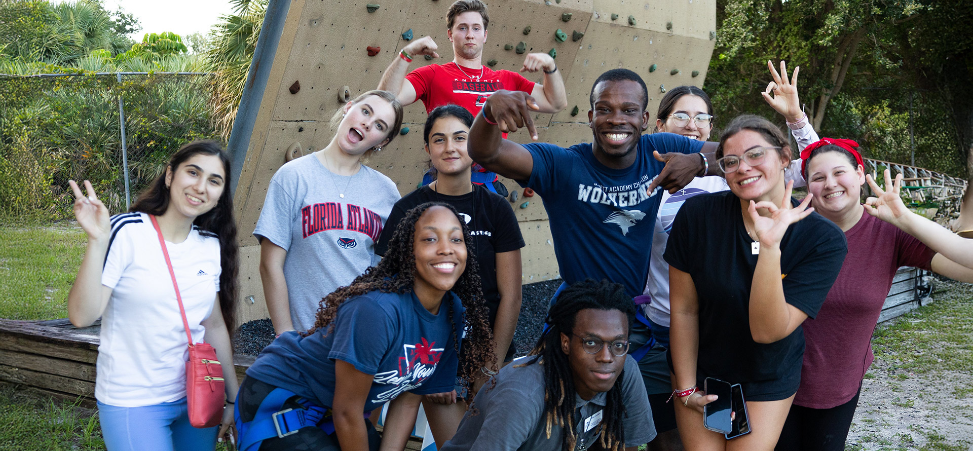 Group of Elite owl students taking a group photo at climbing wall 