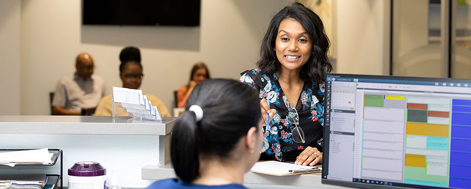 Patient speaking with integrative health office staff member