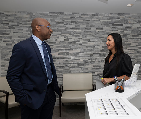 Two people speaking in a clinic lobby