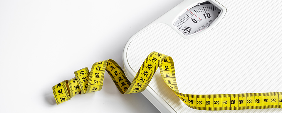 body tape measure rolled out on top of body weight scale