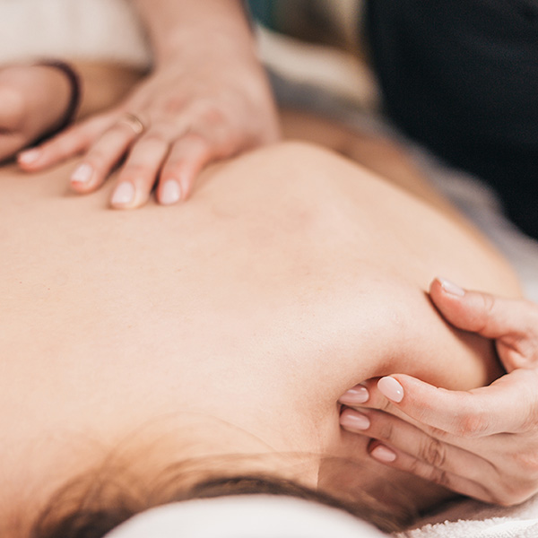 Female osteopath with strong hands professionally helps athletes with physiotherapy after an injury