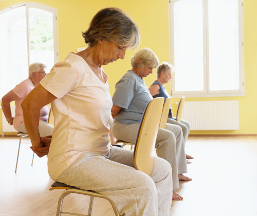 Women performing chair yoga exercises