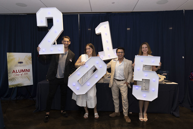 Class of 2015 alum holding numbers 2, 0, 1, and 5 at Alumni Reunion Weekend reception event