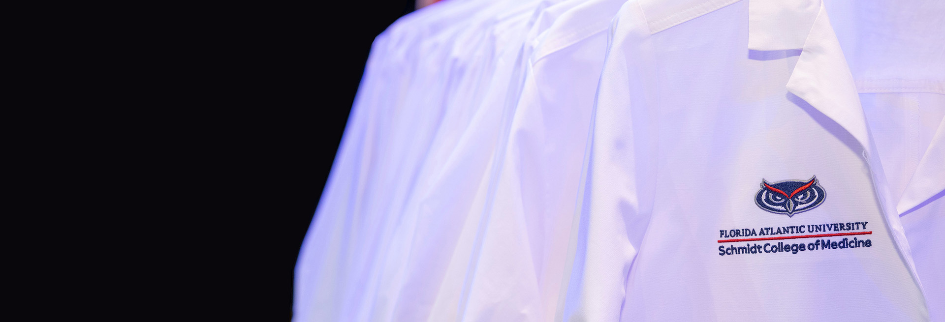 FAU Doctor's white coats on stage