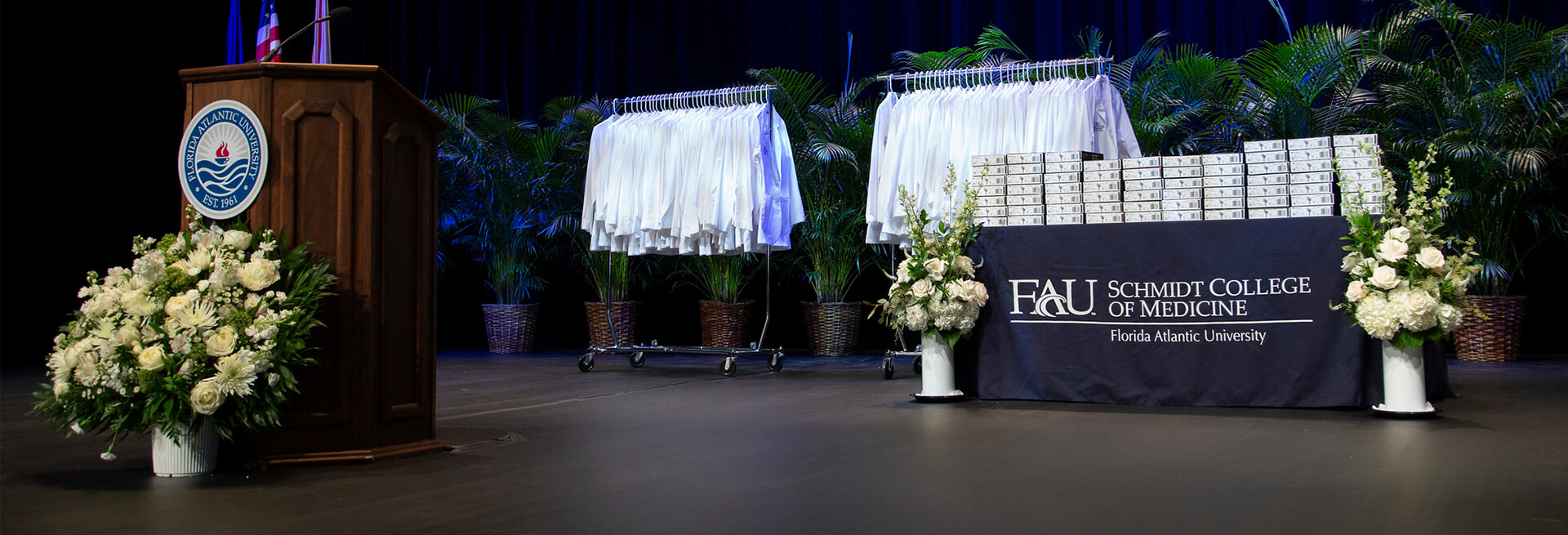 White coats displayed on stage with podium