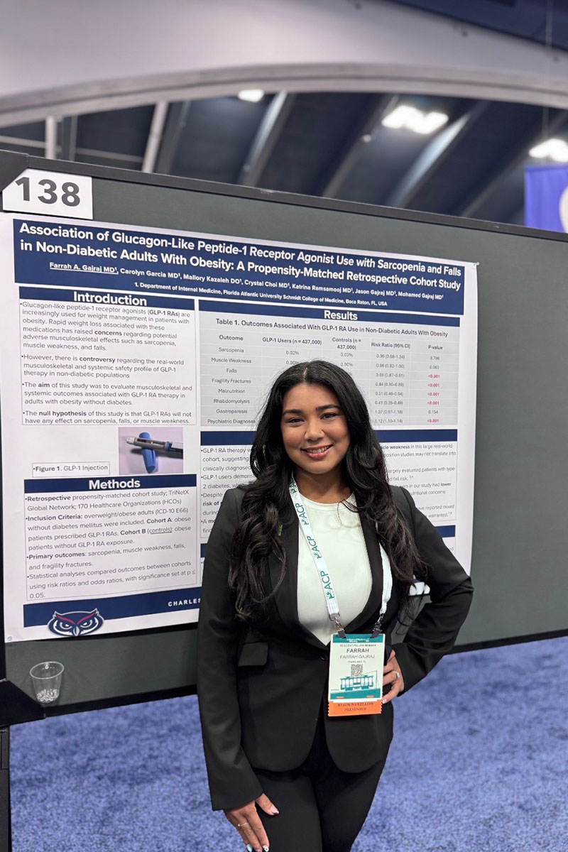 FAU IM resident standing in front of her conference poster