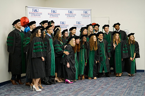 FAU Schmidt College of Medicine graduates taking group picture at 2022 commencement ceremony
