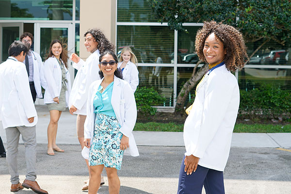 FAU medical students in front of the Schmidt College of Medicine building