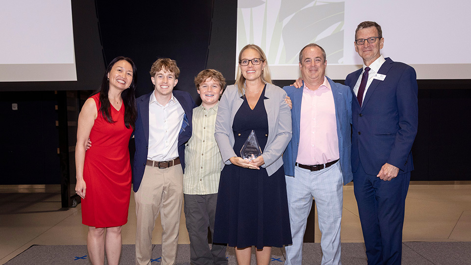 Dr. Ferris and family accepting award from Dean Nelson and Vice Dean Caceres