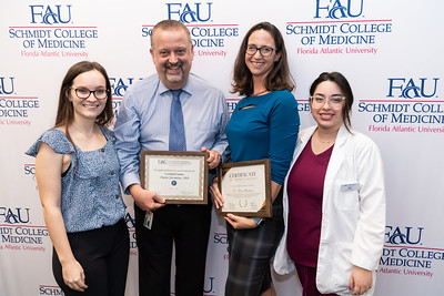 Drs. Mario Jacomino and Lisa Martinez receiving awards with students