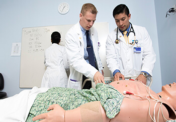 Students examining mannequin at the Clinical Skills Simulation Center