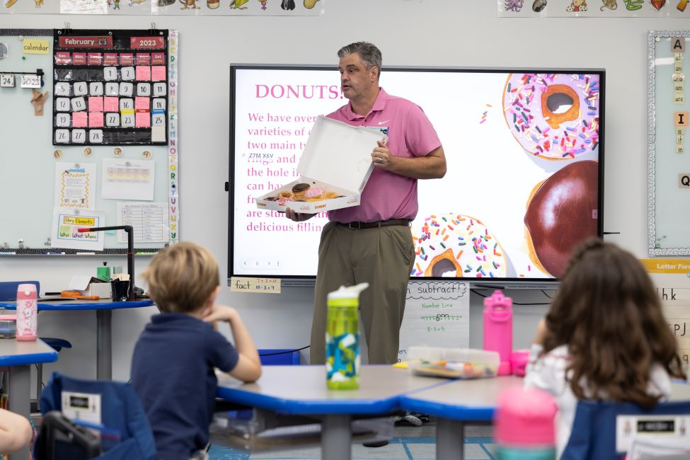 Matt Hufty of Dunkin' presents a box of donuts to a kindergarten class at A.D. Henderson University School.