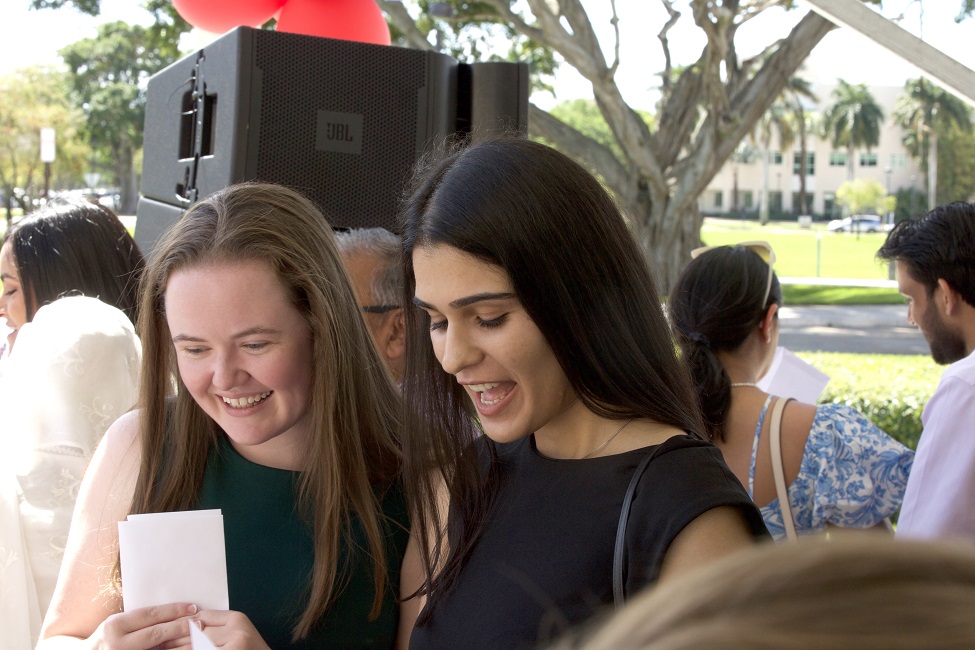 The first two medical students from the FAU High School Med Direct Program: Sarah Palumbo (left) and Nadia Sial, both age 24, open their sealed envelopes.