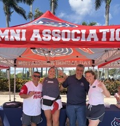 group of alumni under a tailgate tent