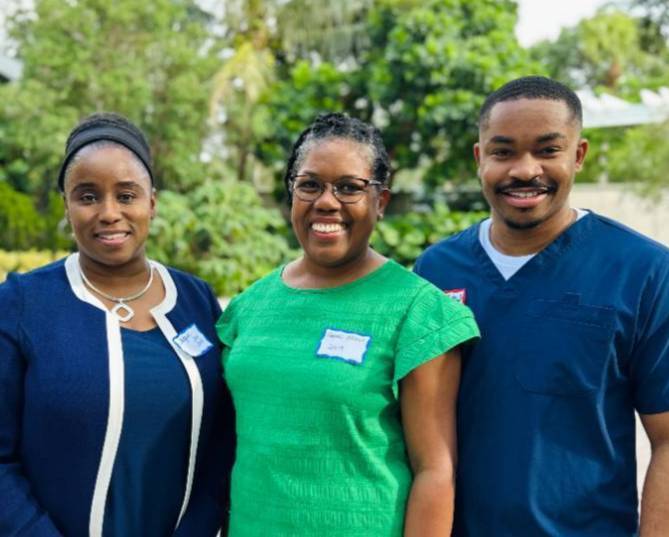 group of three alumni standing and smiling