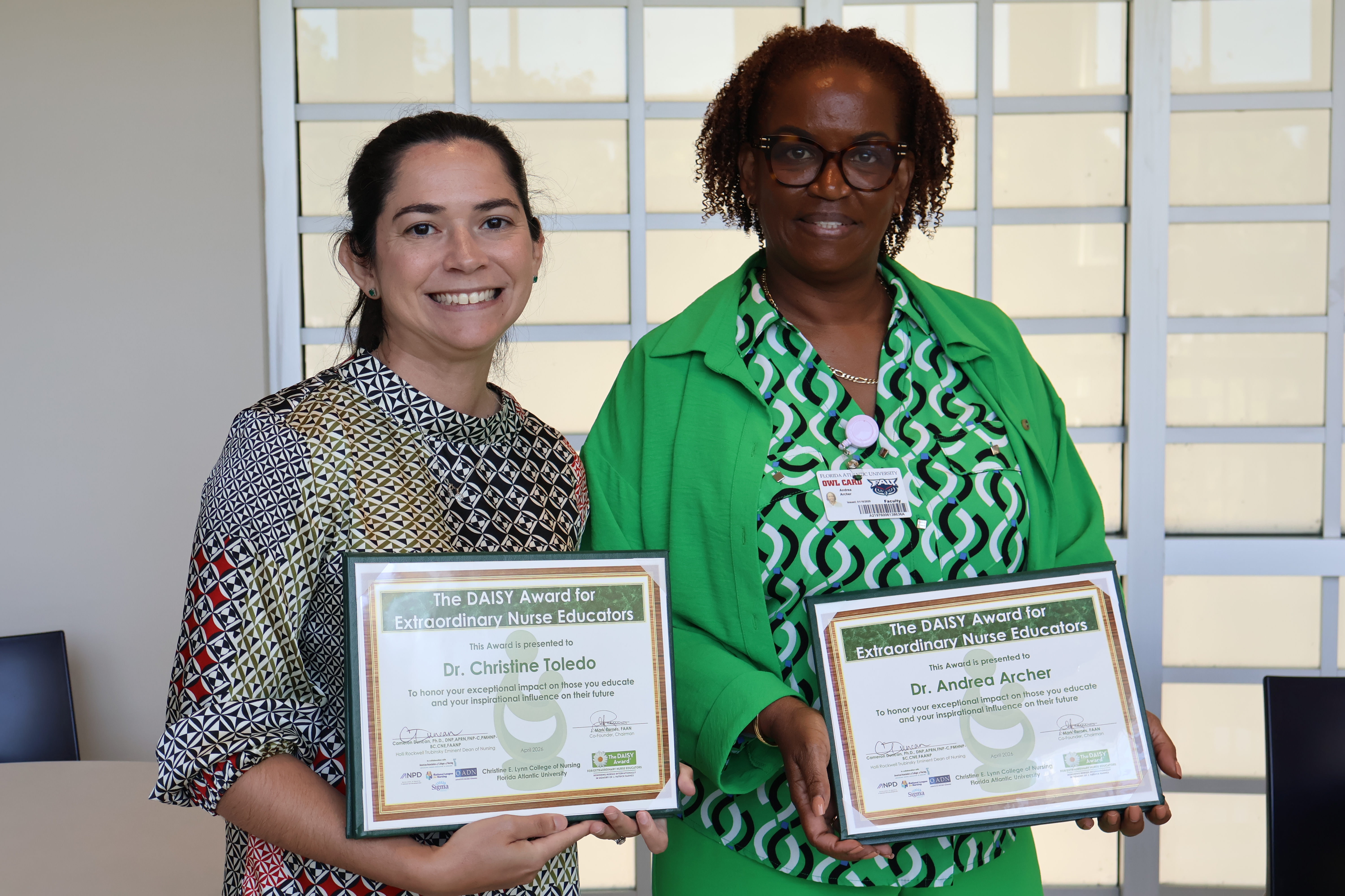 Two faculty members posing with Daisy Awards