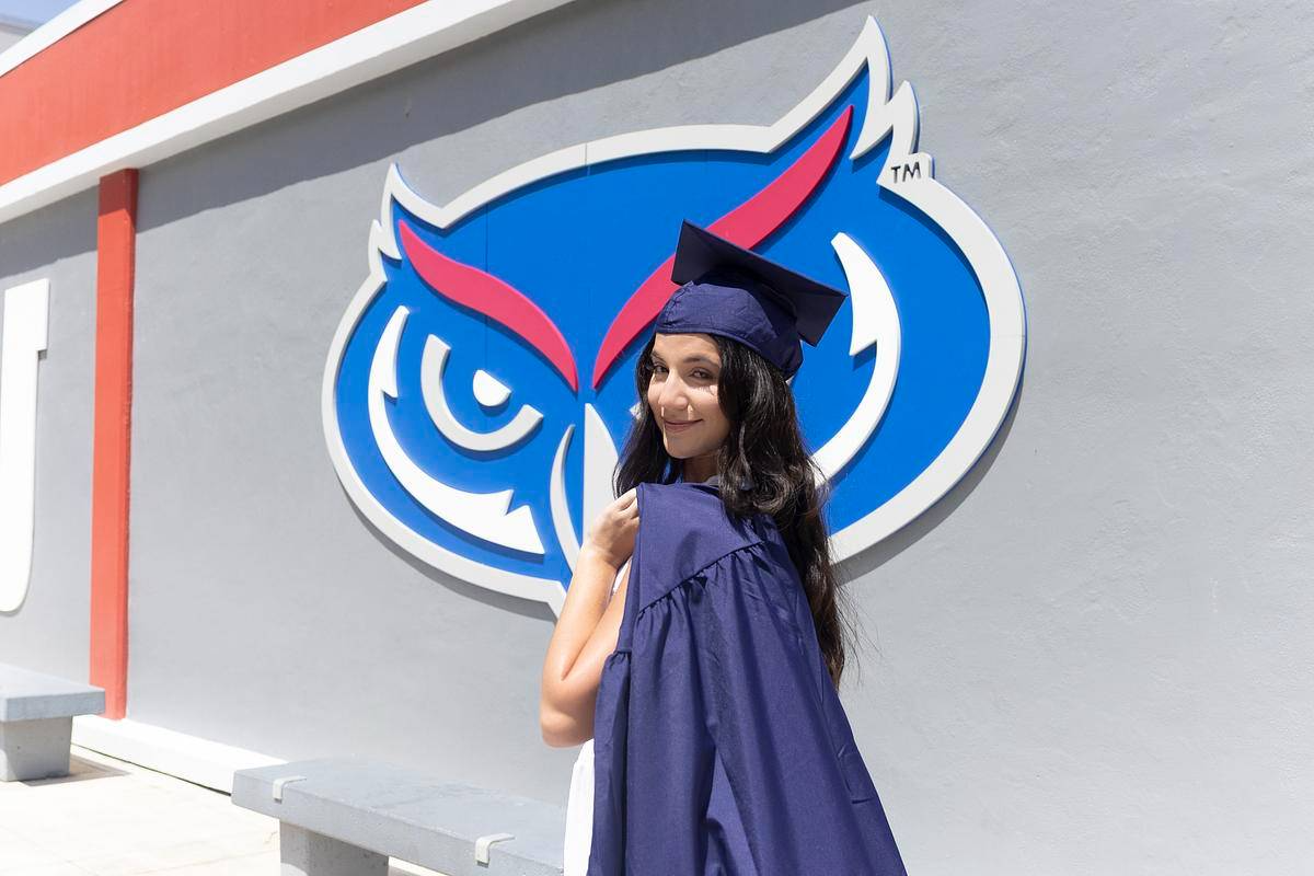 A FAU graduate confidently looking at the camera during commencement.