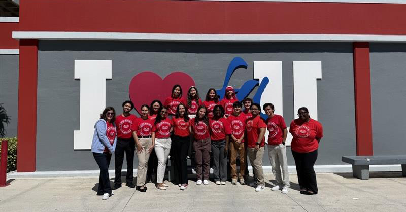 student in front of I love FAU sign