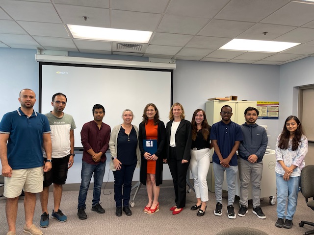 A group of people pose for a photo together in a classroom setting.