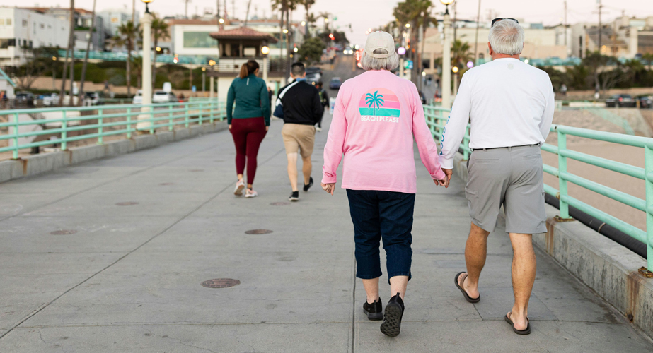woman smiling and holding up arms, on abstract aqua and gray background