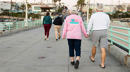 woman smiling with arms out, on abstract blue and gray background